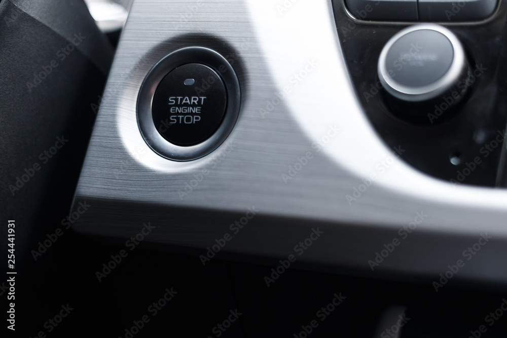 Car Start-Stop Engine Button of a modern car in the interior of the expensive car