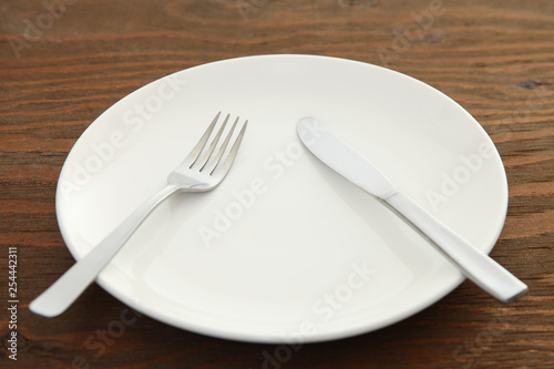 white dish on the brown table with cutlery meaning PAUSE