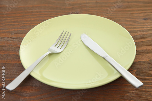 green dish on the brown table with cutlery meaning PAUSE