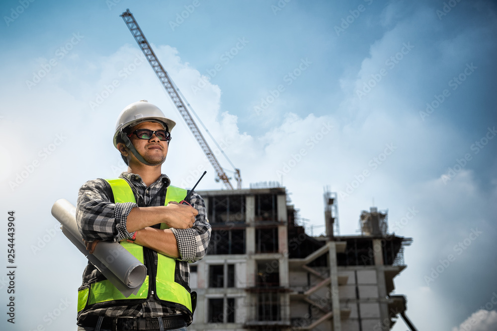 Engineers People holding blueprint in his hand at construction site or building site of highrise building Engineers People holding blueprint in his hand at construction site or building site of highrise building