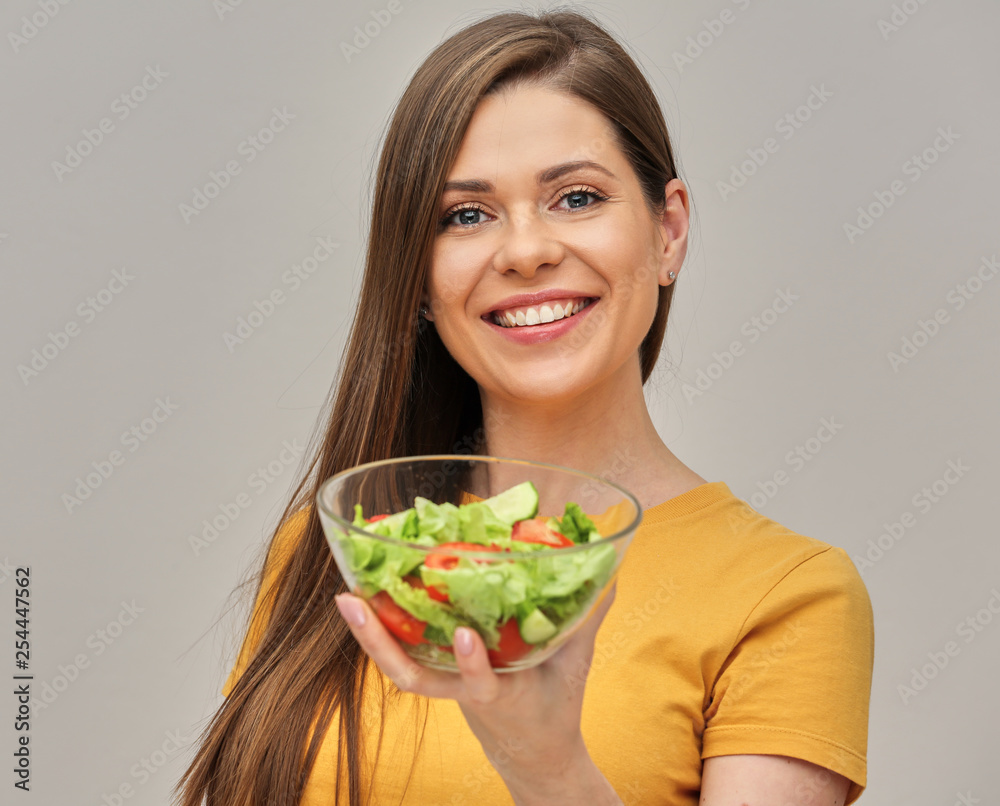 smiling woman holding glass bowl with green salad. smiling woman holding glass bowl with green salad.