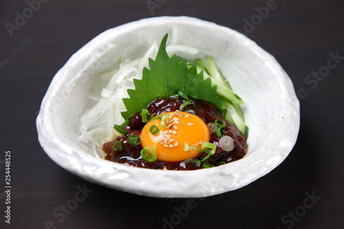 Korean dish of seasoned raw horse topped with an egg yolk