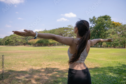 Concept of exercise. Beautiful girl stretching the muscles before running. Women exercising in the garden with freshness.