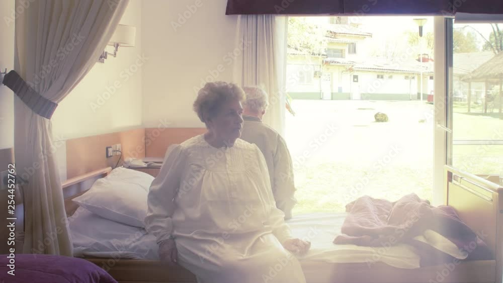 Elderly couple going into hospital bed, sunlight coming from outdoor Elderly couple going into hospital bed, sunlight coming from outdoor