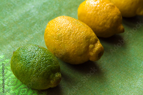four lemons of different maturity lie on a table or on a white background