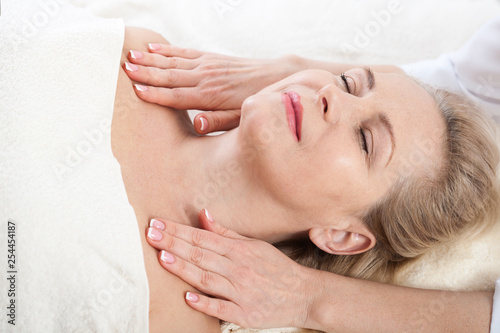 Wallpaper Mural face massage in spa macro. Attractive woman with close eyes taking skin care. Massage face selective focus. Torontodigital.ca
