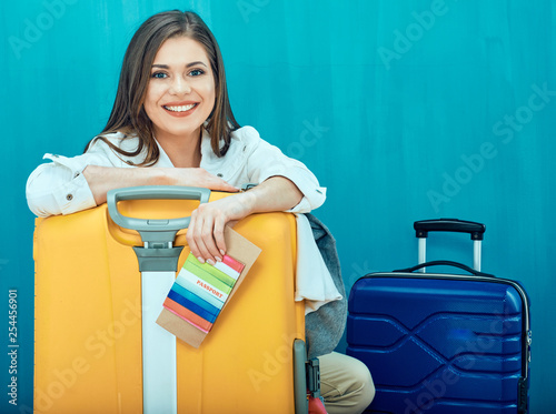 Smiling young woman with two suitcase shows thumb up. photo