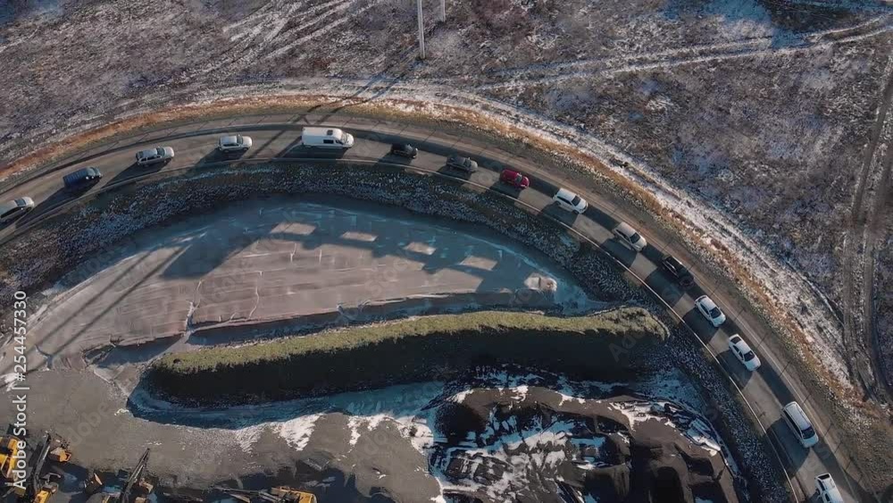 From above picturesque view of route with queue of automobiles around cranes and trucks parked on land in sunny day From above picturesque view of route with queue of automobiles around cranes and trucks parked on land in sunny day