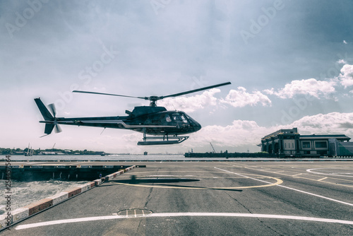 Fototapeta Czarny helikopter lecący na wycieczkę po mieście