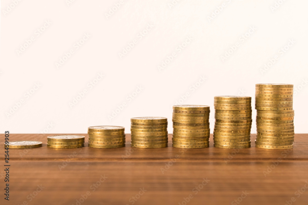 Stacks of coins on a wooden table. Business concept and growth of capital. Stacks of coins on a wooden table. Business concept and growth of capital.