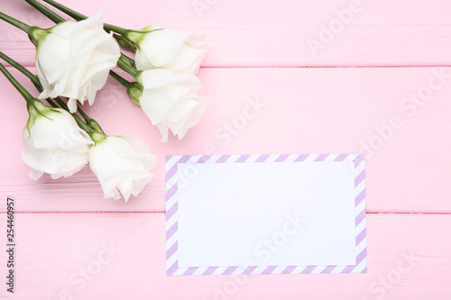 Greeting card with eustoma flowers on pink wooden table © 5second