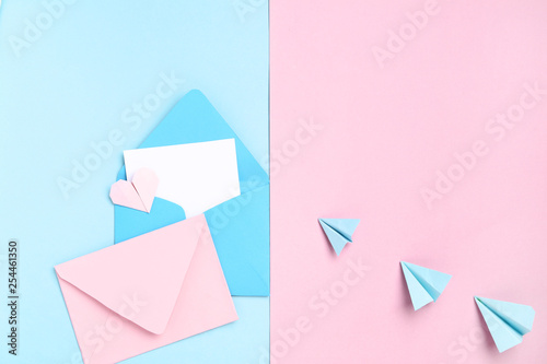 Blue and pink envelopes with paper planes on colorful background