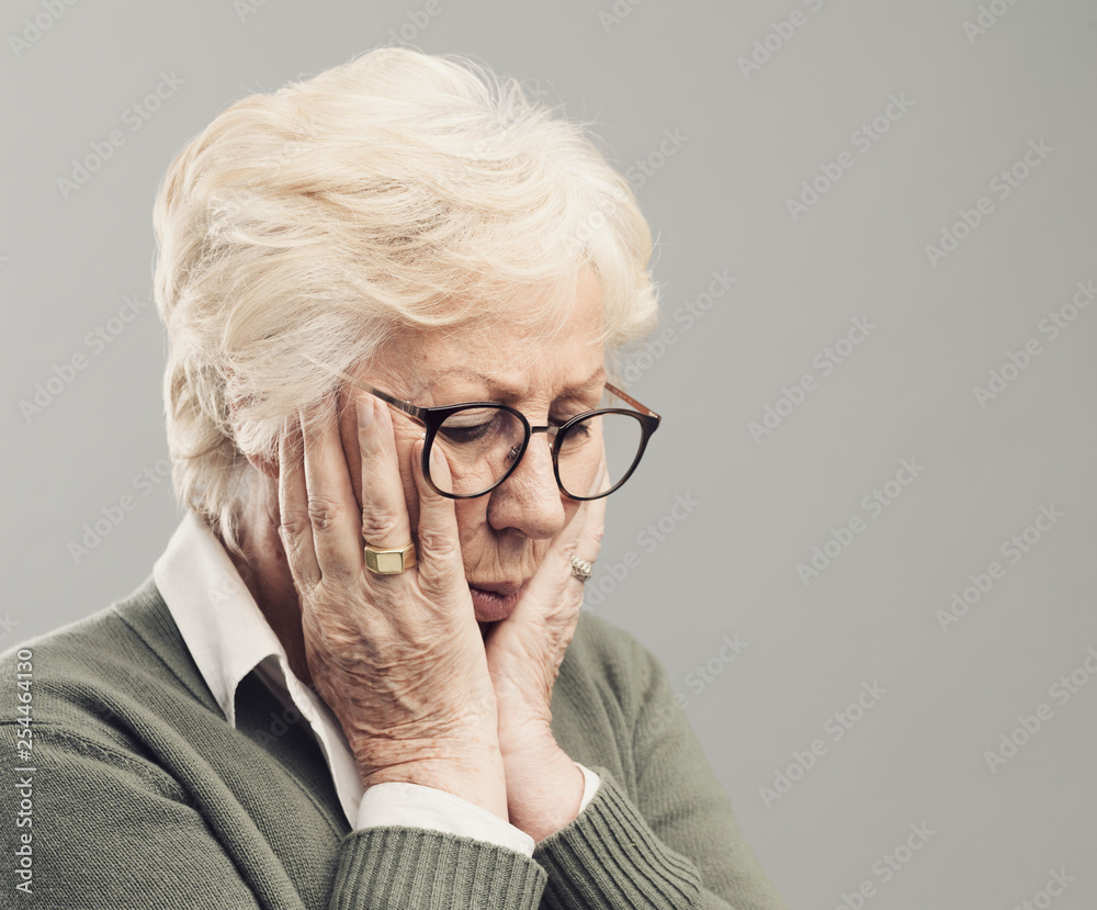 Sad lonely elderly woman posing with head in hands Sad lonely elderly woman posing with head in hands
