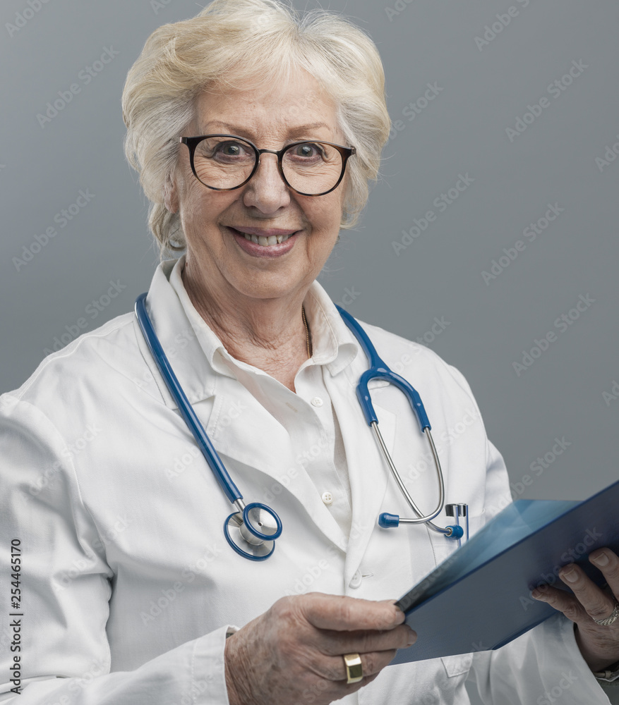 Confident senior female doctor posing and smiling Confident senior female doctor posing and smiling