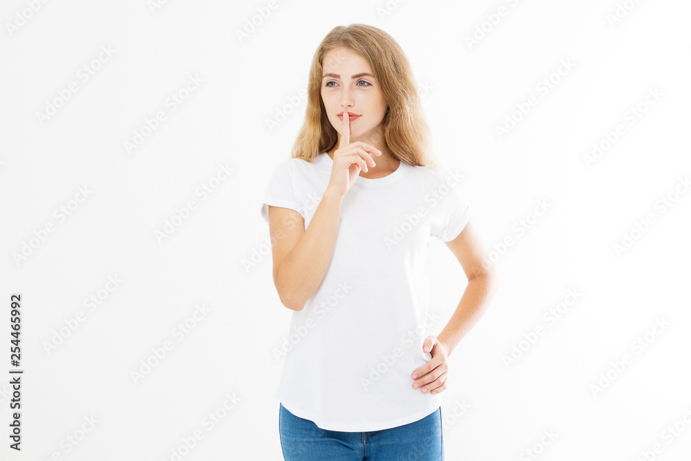 Shhh sign. Young woman showing shh gesture to keep a silent. Girl in template white t shirt keep a secret. Quiet place and silence time. Copy space Shhh sign. Young woman showing shh gesture to keep a silent. Girl in template white t shirt keep a secret. Quiet place and silence time. Copy space