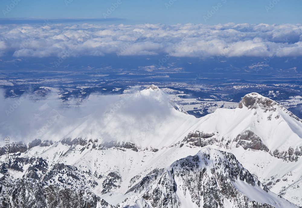 Fototapeta premium Clouds Sweeping Across Snow-Covered Peaks in the High Tatras, Slovakia