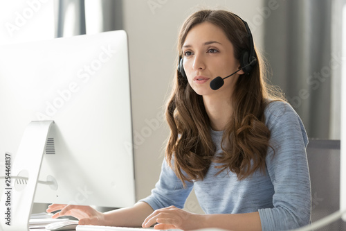 Businesswoman in headset call center agent consulting participating video conference