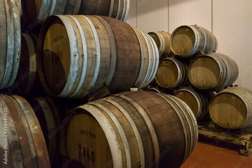 Wine barrels stacked in the old cellar of the winery. 