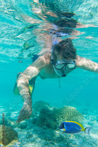 Man snorkeling above a shallow reef.Underwater view.