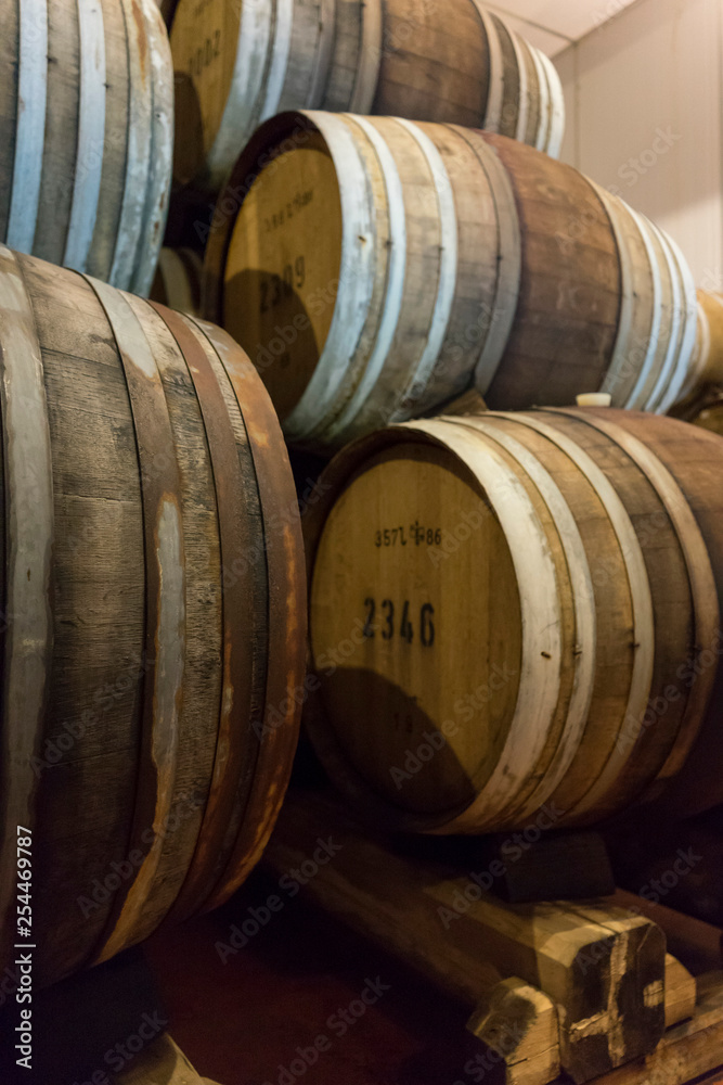 Wine barrels stacked in the old cellar of the winery. Wine barrels stacked in the old cellar of the winery.