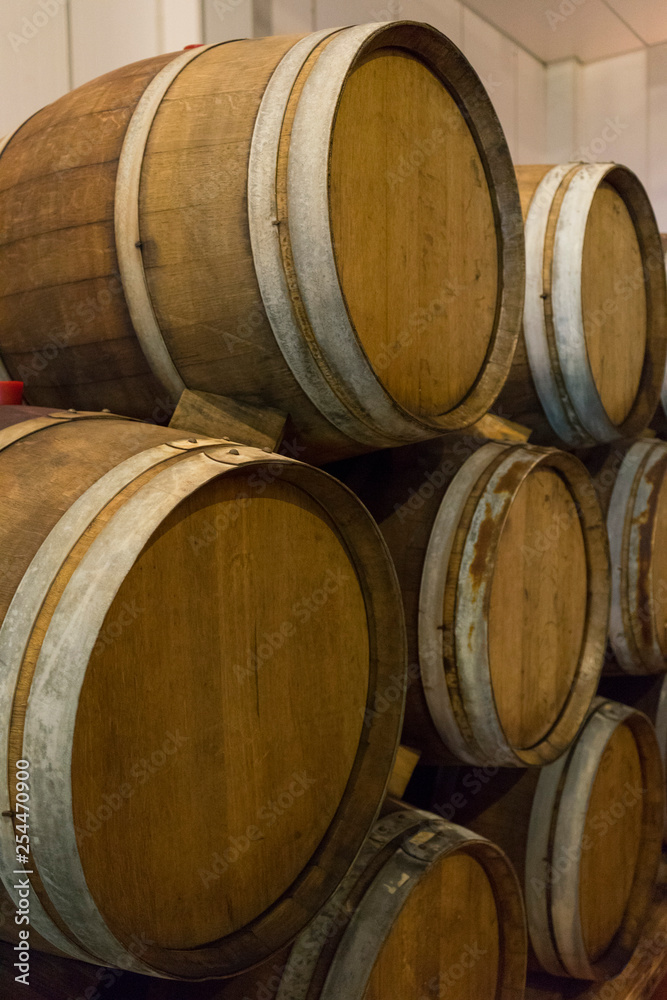 Wine barrels stacked in the old cellar of the winery. 