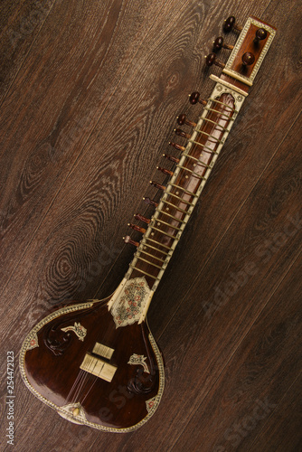 Fotografie Indian musical instrument sitar lying on the wooden floor