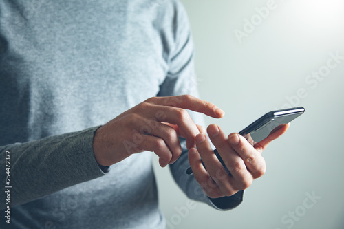 man hand holding smart phone photo