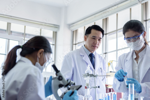 Asian scientist team has researching in laboratory.