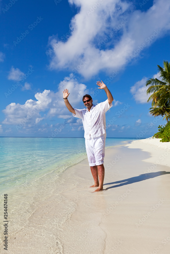 Happy man with arms outstretched on the tropical beach Happy man with arms outstretched on the tropical beach
