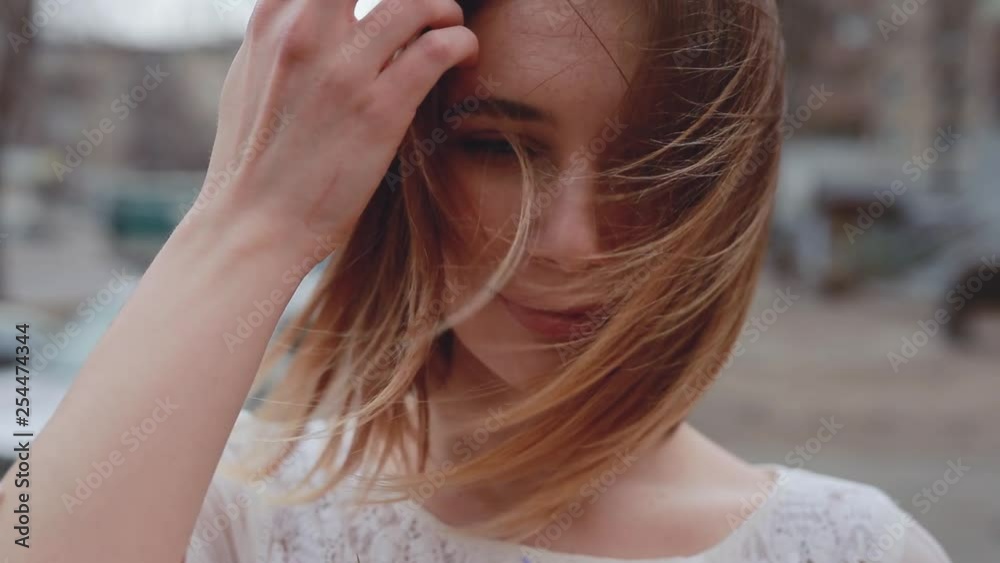 Closeup portrait of wind blows beautiful woman hair, slow motion