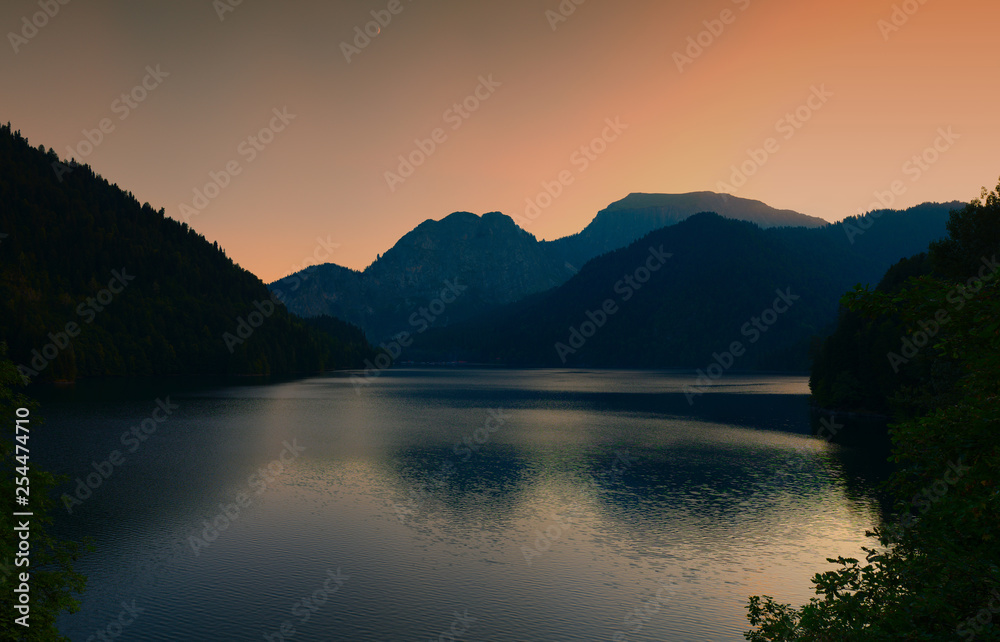 Silhouettes of mountains at sunset on a mountain lake