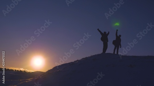 Man teamwork business travel silhouette concept. two hikers winter snow tourists climbers climb to the top of mountain lifestyle . overcoming hardships the path to victory, teamwork, important points.