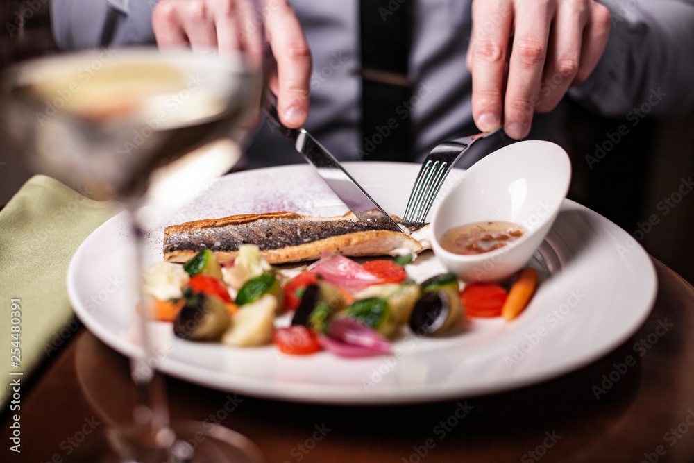 Plate with tasty cooked seabass fish and vegetables on table