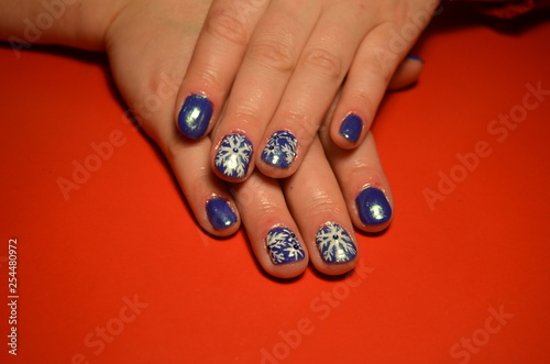 Beautiful female hands with a New Years Nail Design on a Red Background