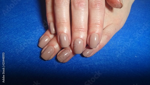 Beautiful female hands with a stylish nail design on a blue background