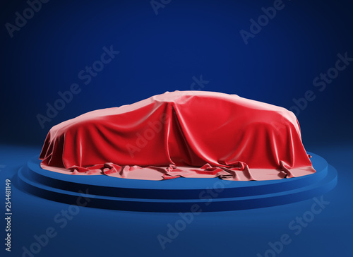 Car on the podium covered with a red satin cloth before presentation. Clipping path incluted. photo