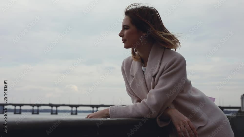 Woman looking forward at river thinking and dreaming outdoors over sky background