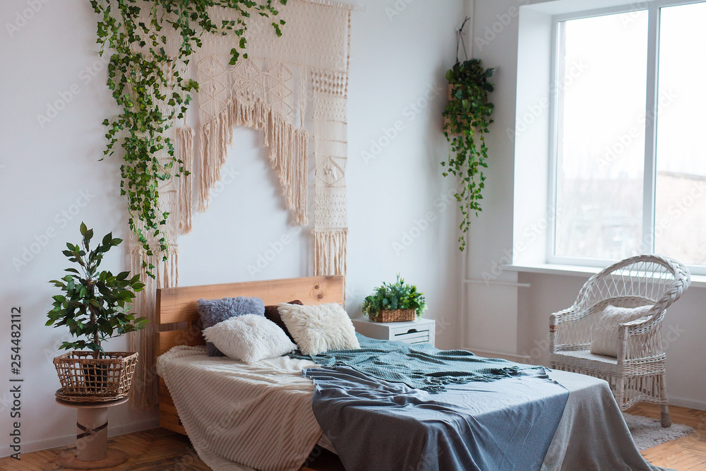 Cozy interior design of modern studio apartment in Scandinavian style. A spacious huge room in light colors with wooden bed and stylish expensive luxury furniture. Cozy interior design of modern studio apartment in Scandinavian style. A spacious huge room in light colors with wooden bed and stylish expensive luxury furniture.