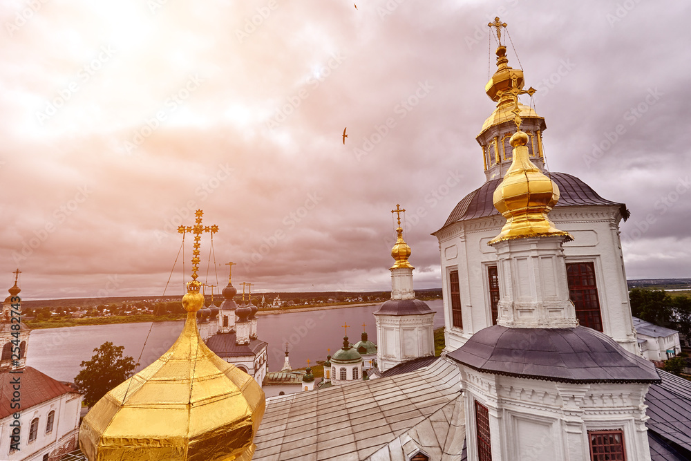 Fototapeta premium Eastern orthodox crosses on gold domes, cupolas, against blue sky with clouds