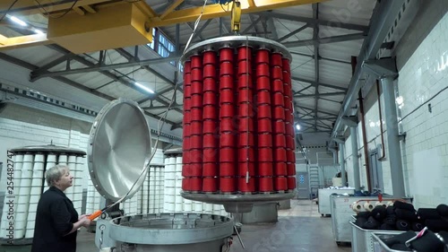 Textile factory female worker works with thread coloring machine. Modern technology in dyeing yarns with Machines for Textile Industry, Dyeing Machine Chemical Tanks