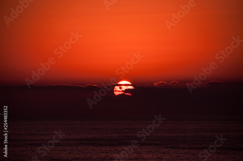 Sunset in red behind black clouds 2