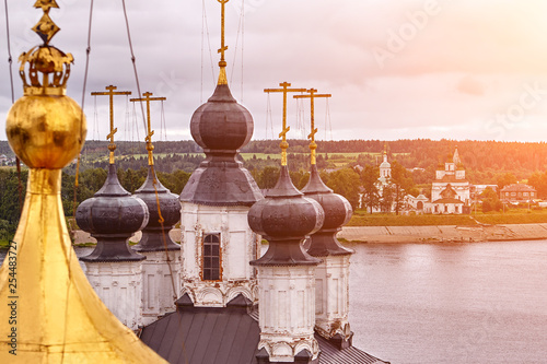 Eastern orthodox crosses on gold domes, cupolas, against blue sky with clouds photo