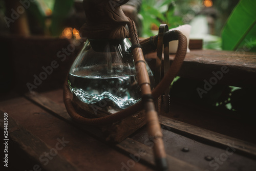 Asian hookah with autentic glass bowl is on the wood table in Bali photo