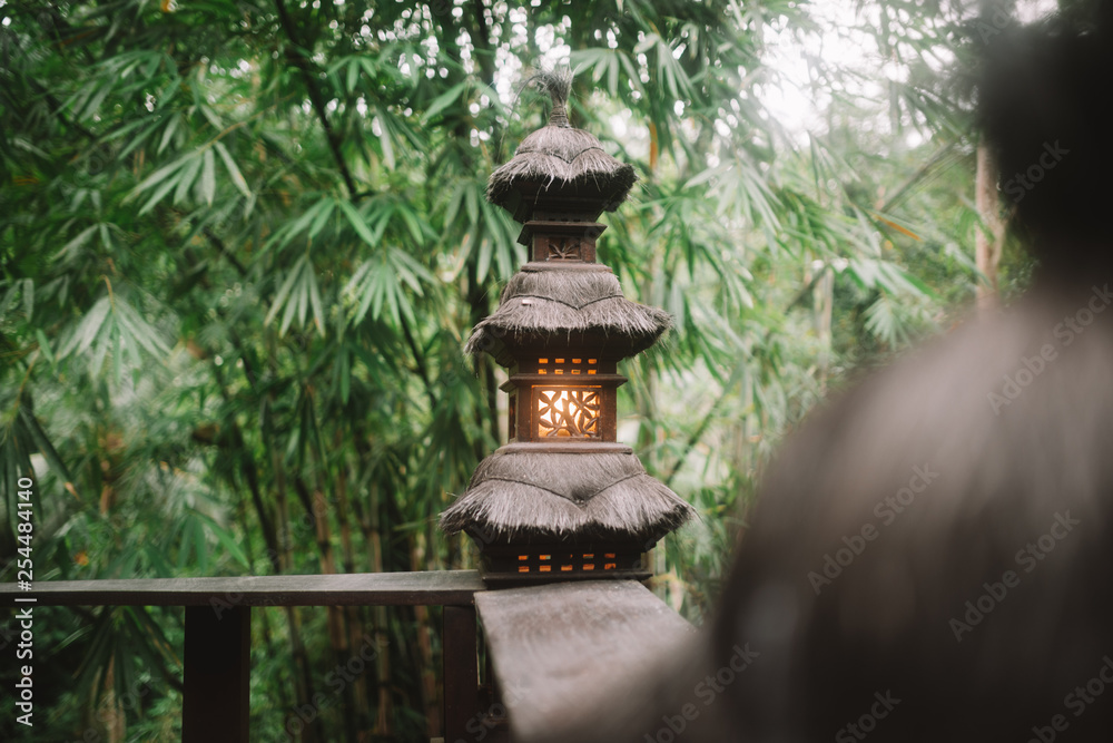 black asian street light at the wood veranda on tropical forest background in Bali black asian street light at the wood veranda on tropical forest background in Bali