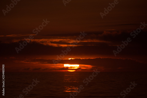 Sun behind clouds on a fired sky 3