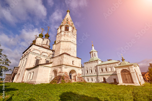 Old orthodox church at village. Summer view with floral meadow. Sun flare