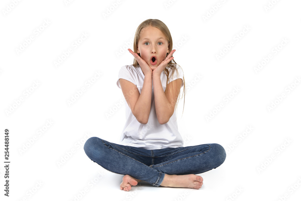 Junges Mädchen sitzt auf dem Boden und schaut erstaunt Junges Mädchen sitzt auf dem Boden und schaut erstaunt