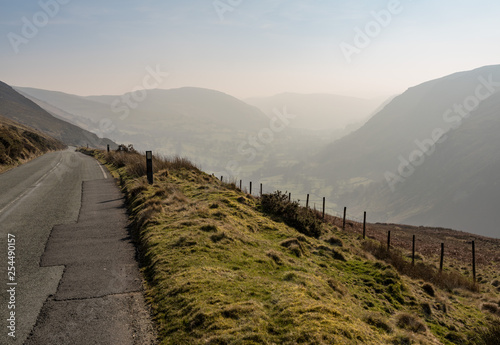 Narrow road out of Llangynog in North Wales over the hills to Bala with misty valley behind photo