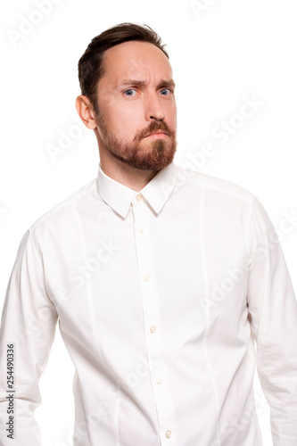 Handsome bearded man in a white shirt poses, isolated on a white background