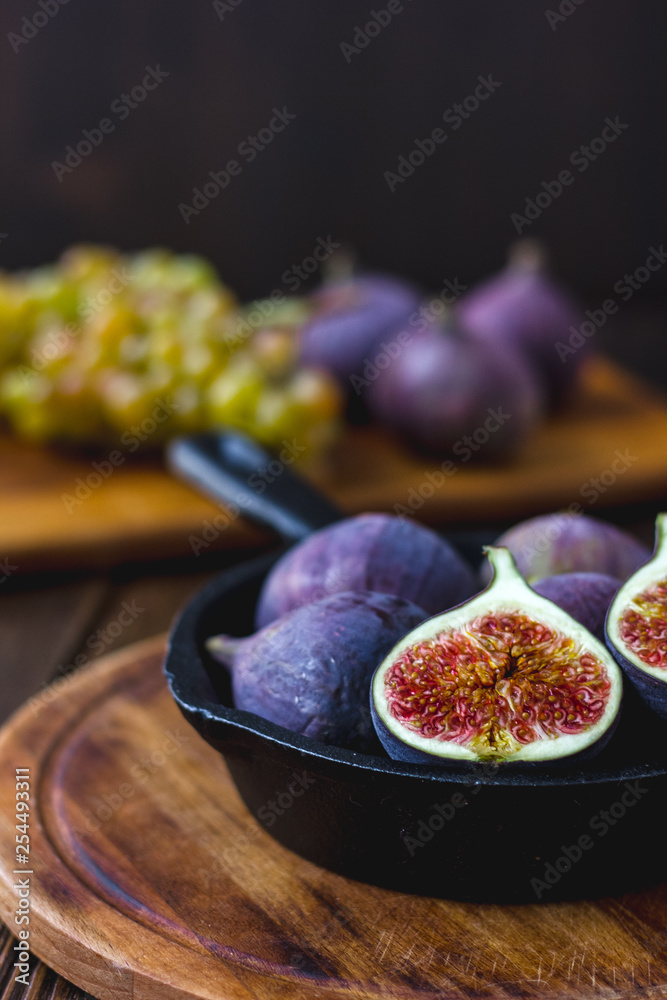 Fresh and ripe figs inside frying pan over wooden table. Fresh and ripe figs inside frying pan over wooden table.